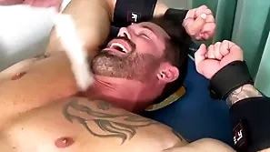 Muscular hunk endures bondage and torment on half scant body